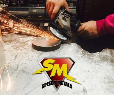 Hands holding a saw cutting a round piece of metal with sparks flying. Below is the Speedy Metals logo, a yellow capital S and capital M on a red, diamond background with the words Speedy Metals below.